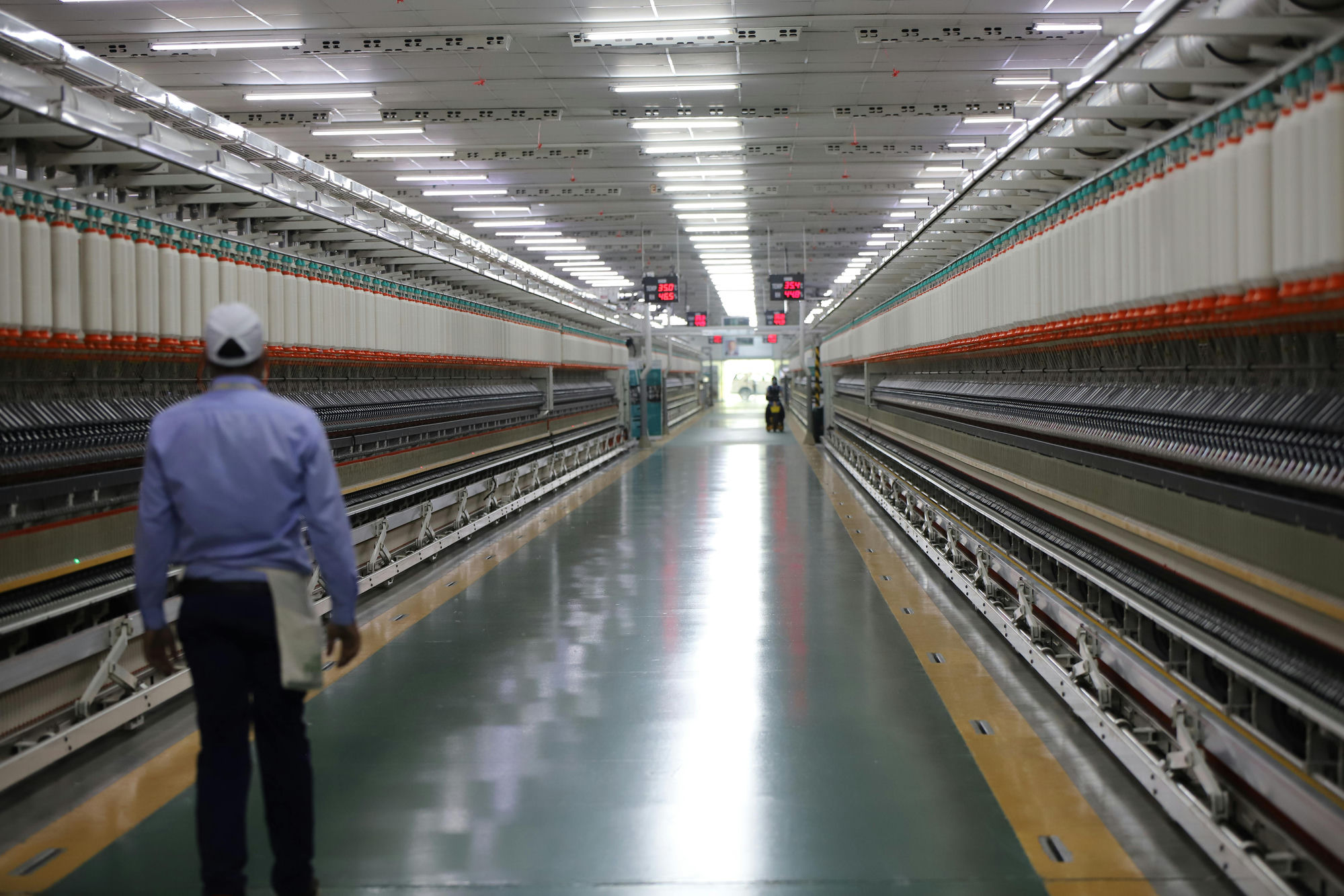 Worker walking the long aisle of a modern industrial line